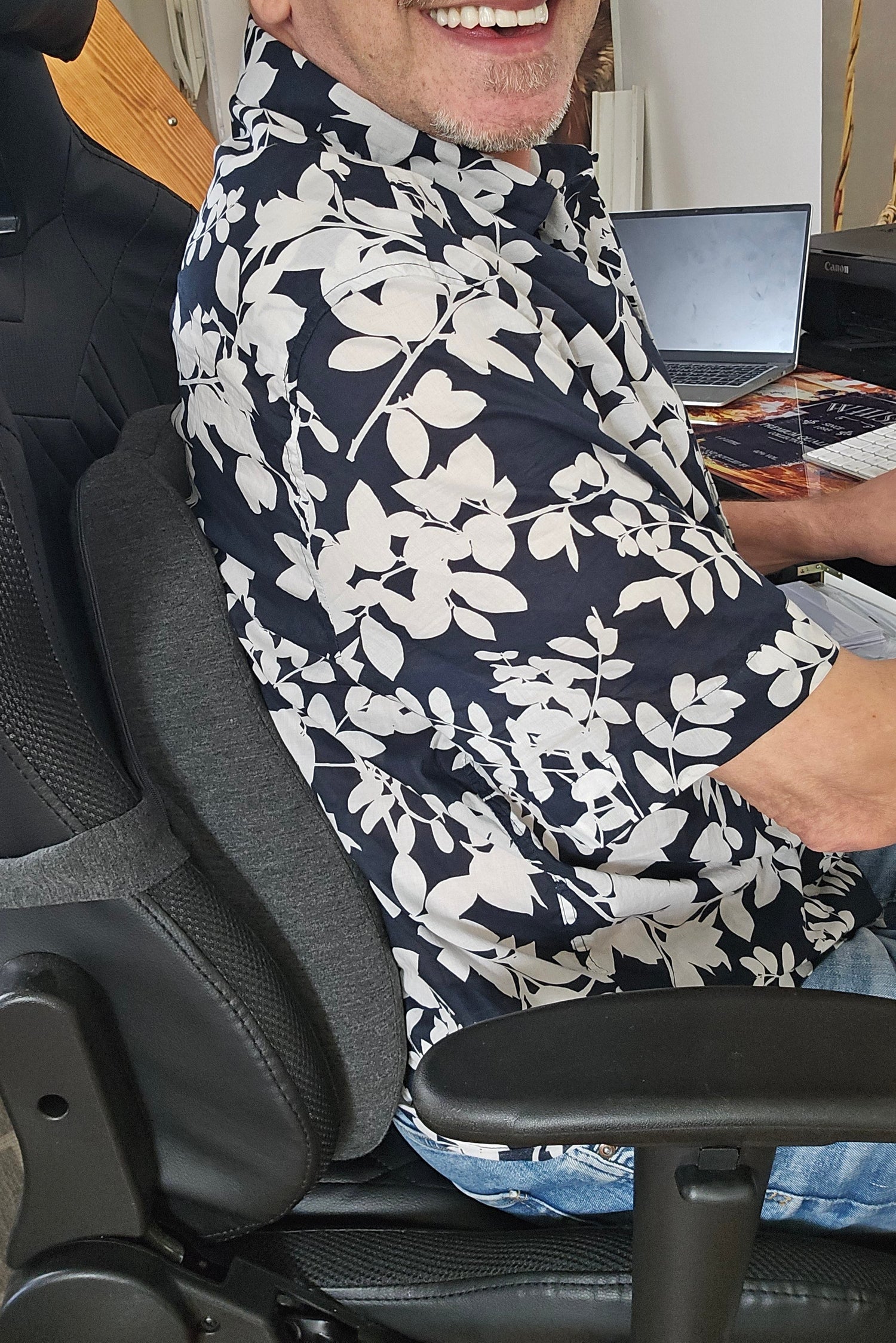 ErgoSupport Rückenkissen für Bürostühle, Benutzer lächelt während der Nutzung für optimalen Komfort bei der Arbeit.
